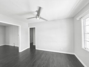 Interior Unit Living Room, dark wood floors, white walls, ceiling fan