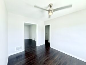 Interior Unit Living Room, dark wood floors, white walls, ceiling fan