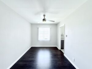 Interior Unit Dining room, unit entrance foyer, ceiling fan in dining room, dark brown wood floors entryway to kitchen.