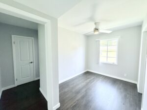 Interior Unit Dining room, unit entrance foyer, ceiling fan in dining room, dark brown wood floors.