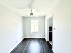 Interior Unit Dining room, unit entrance foyer, ceiling fan in dining room, dark brown wood floors entryway to kitchen.
